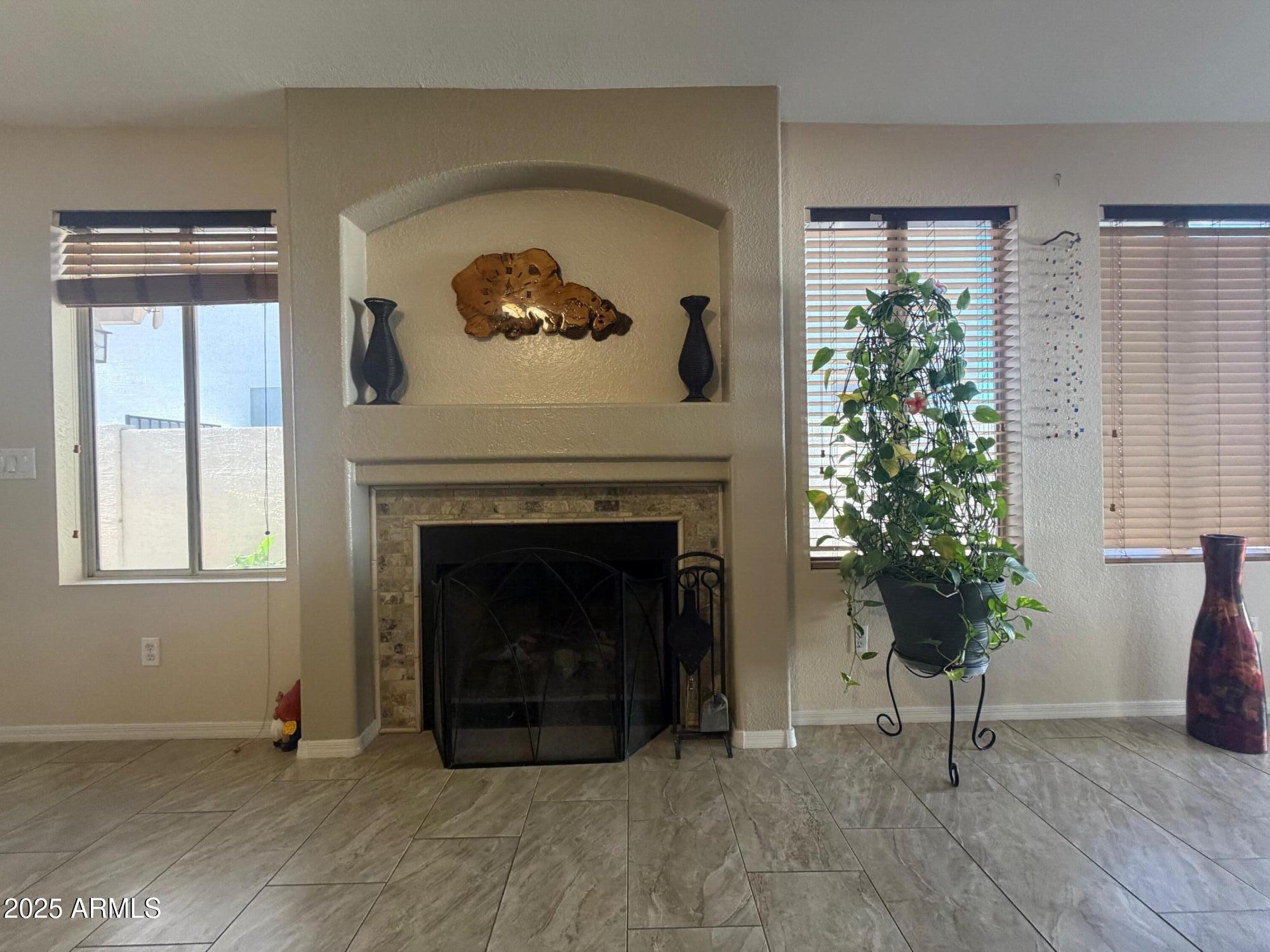 112 West Smoke Tree Road Gilbert, AZ 85233 - Photo 11 of 37 a living room with a fireplace and a large window