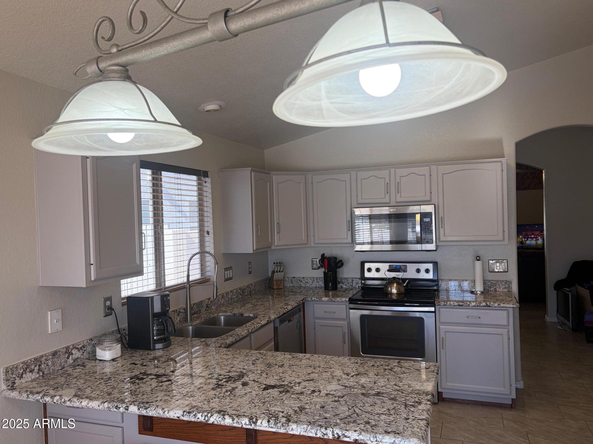 112 West Smoke Tree Road Gilbert, AZ 85233 - Photo 13 of 37 a kitchen with stainless steel appliances granite countertop a sink a stove a refrigerator cabinets and a counter top space