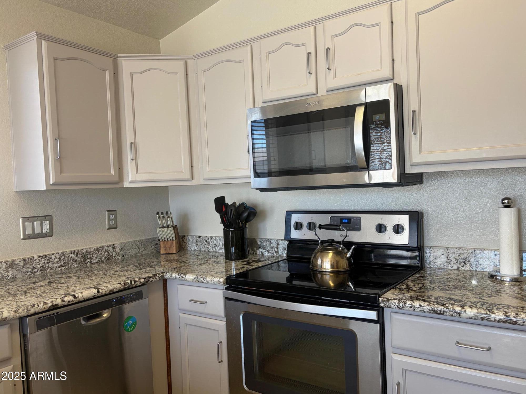 112 West Smoke Tree Road Gilbert, AZ 85233 - Photo 16 of 37 a kitchen with granite countertop white cabinets and appliances
