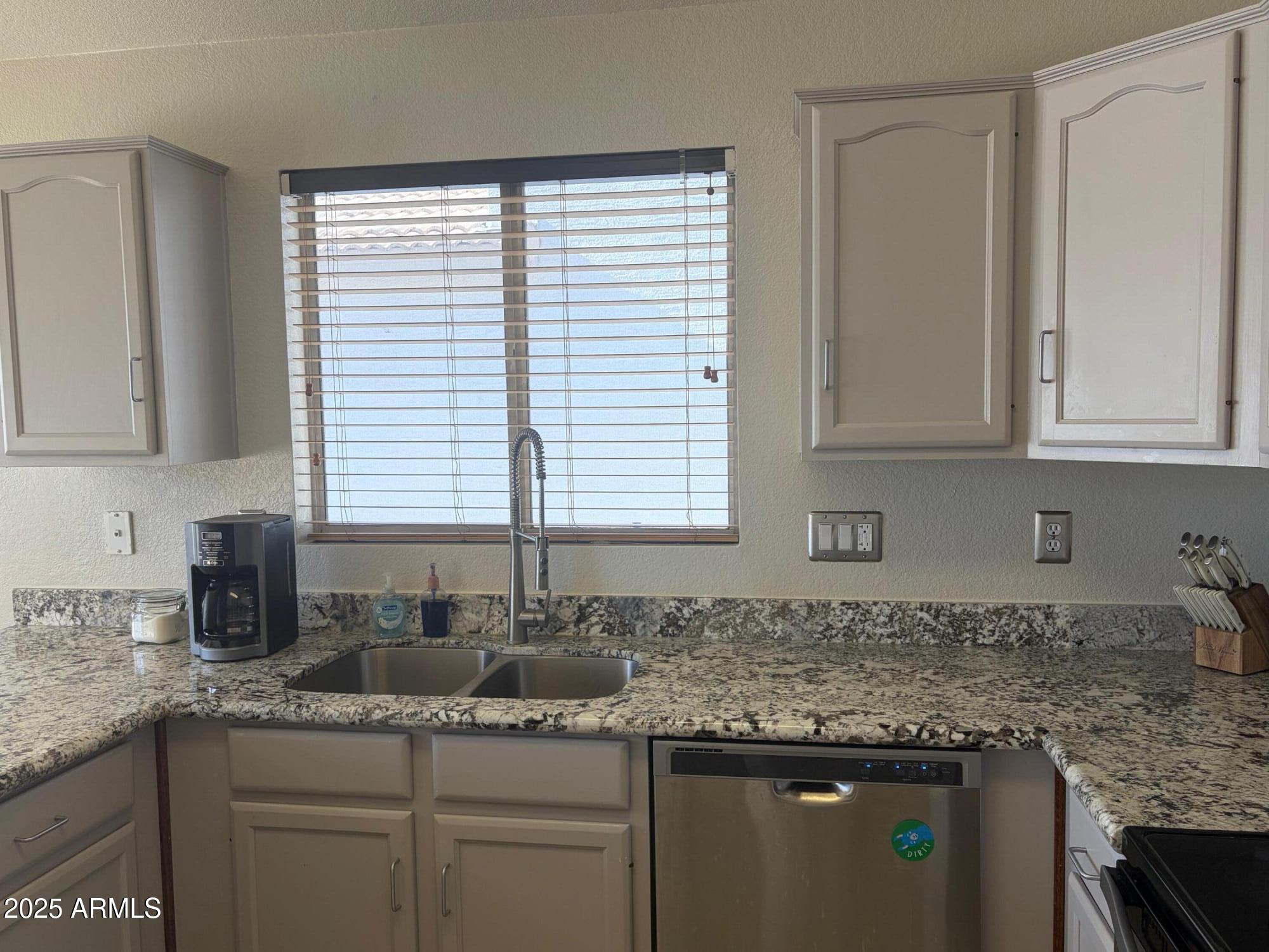 112 West Smoke Tree Road Gilbert, AZ 85233 - Photo 17 of 37 a kitchen with granite countertop white cabinets and a window