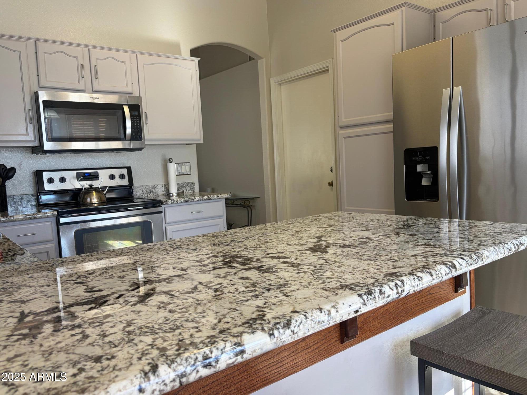 112 West Smoke Tree Road Gilbert, AZ 85233 - Photo 18 of 37 a kitchen with kitchen island sink refrigerator and microwave