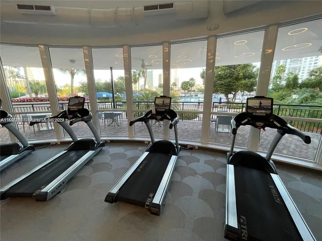 a view of a room with gym equipment and floor to ceiling window