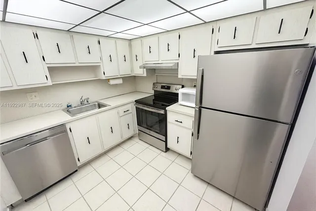 a kitchen with stainless steel appliances a refrigerator sink and cabinets