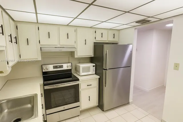 a kitchen with stainless steel appliances a refrigerator sink and cabinets