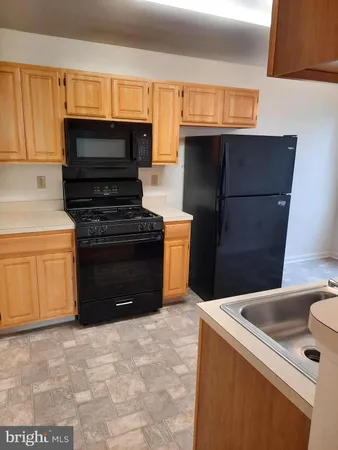 a kitchen with granite countertop a stove and a microwave