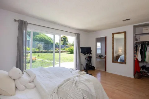 a bedroom with a bed and a large window with outer view