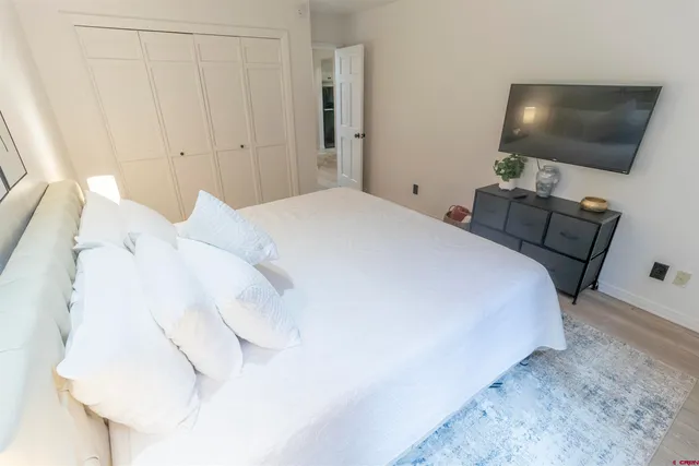 a bedroom with a bed and a flat screen tv