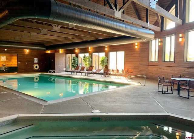 a view of a swimming pool with a lawn chairs and a barbeque