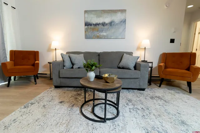 a living room with furniture a rug and a table