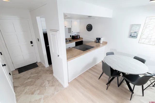 a kitchen with a sink a refrigerator a rug and wooden floor