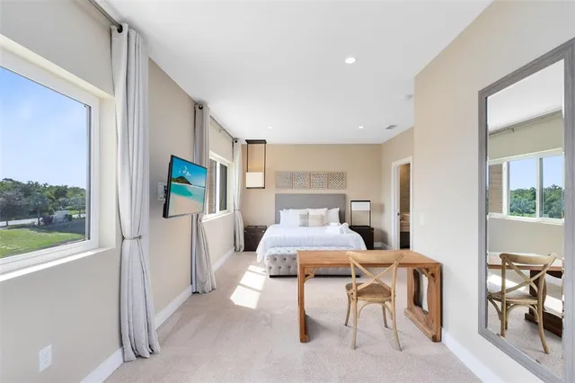 a bedroom with furniture and a large window