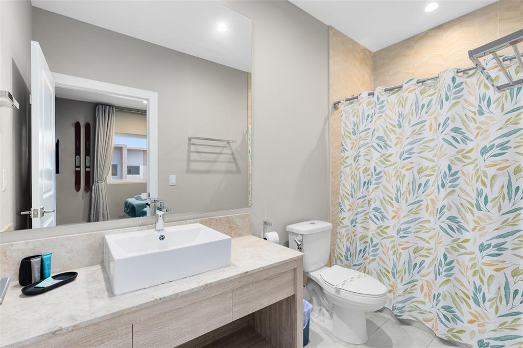 3061 Rockefeller Way Kissimmee, FL 34747 - Photo 17 of 38 a bathroom with a sink toilet a mirror and shower curtain