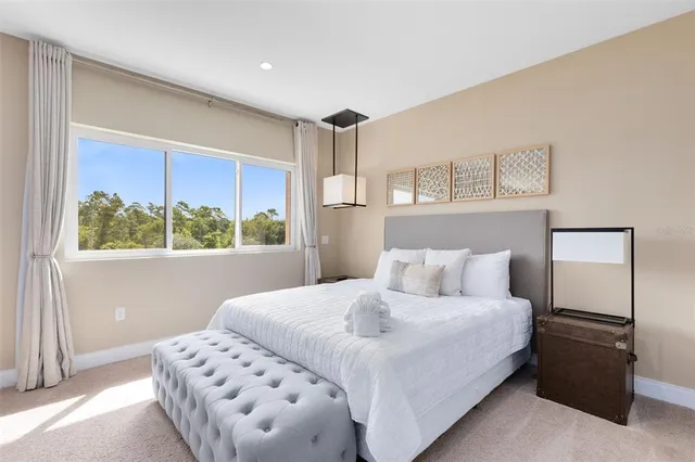 a large bedroom with bed and glass door