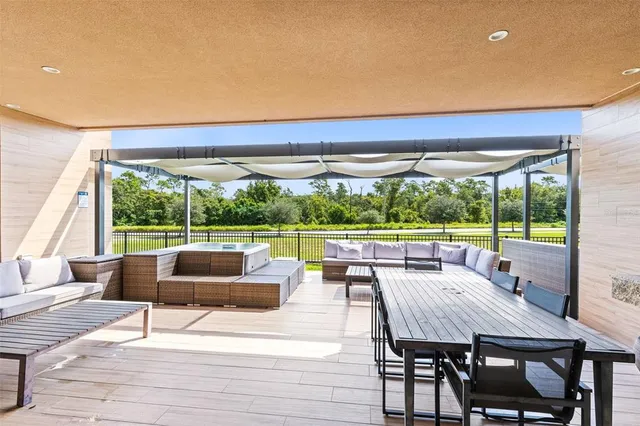 a dining room with furniture and a floor to ceiling window
