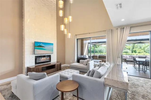 a living room with furniture a flat screen tv and a large window