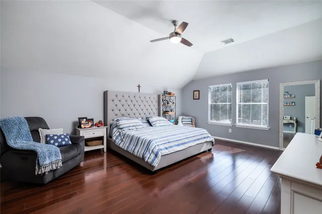 a bedroom with a bed a couch and dresser