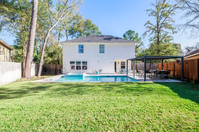 a view of a house with a yard patio and swimming pool