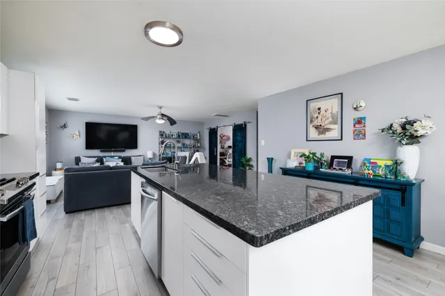 a kitchen with stainless steel appliances granite countertop a sink dishwasher stove and oven with wooden floor