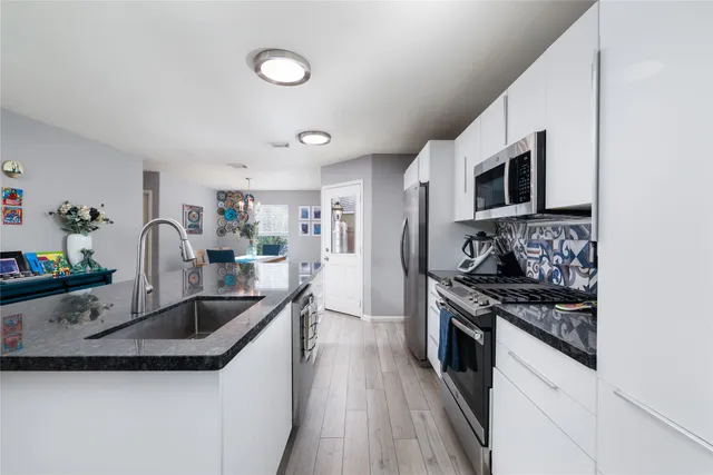 a kitchen with stainless steel appliances granite countertop a sink stove oven and refrigerator