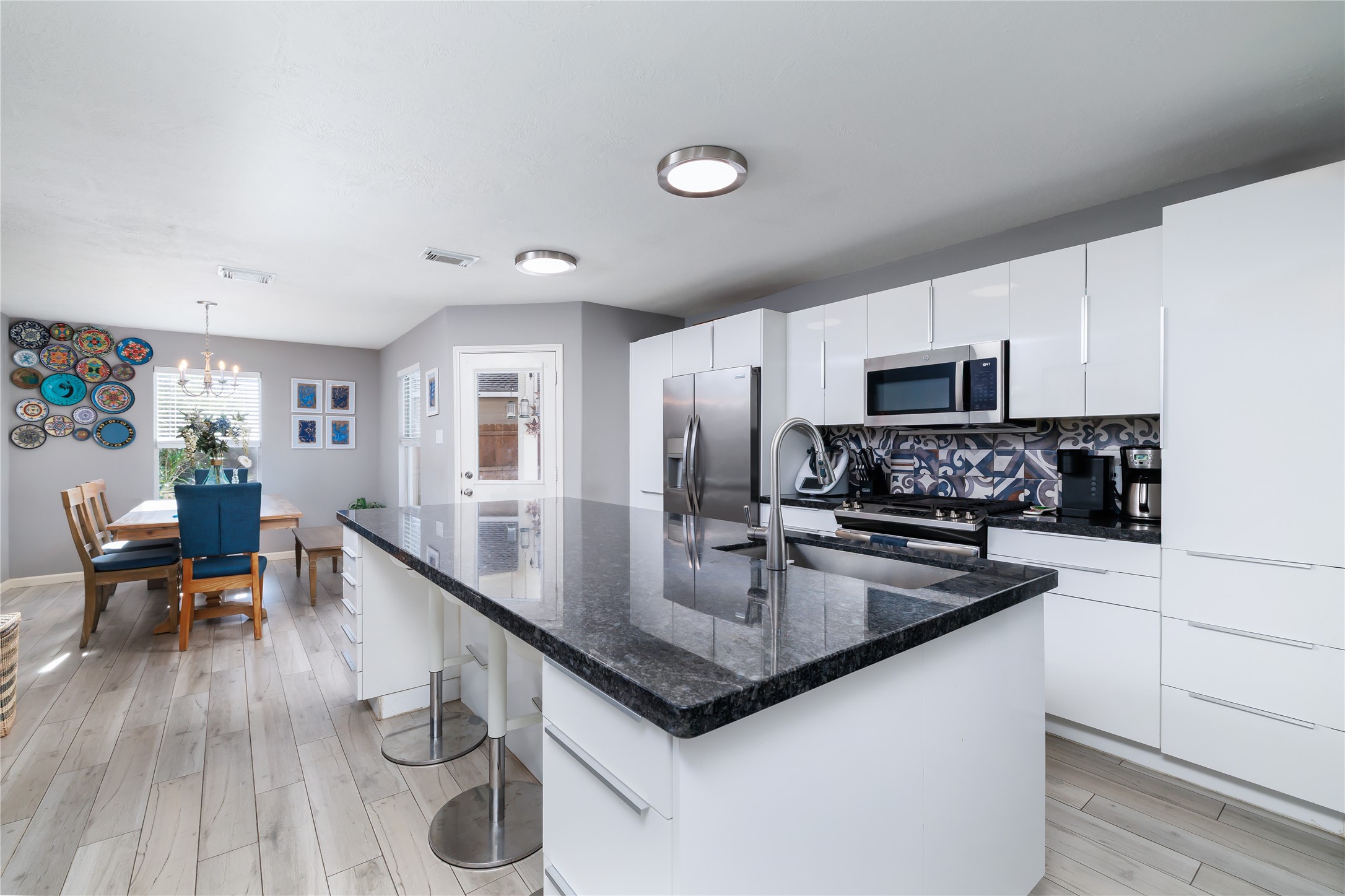 143 South Vesper Bend Circle Spring, TX 77382 - Photo 10 of 31 a kitchen with stainless steel appliances granite countertop a sink dishwasher stove and microwave with wooden floor