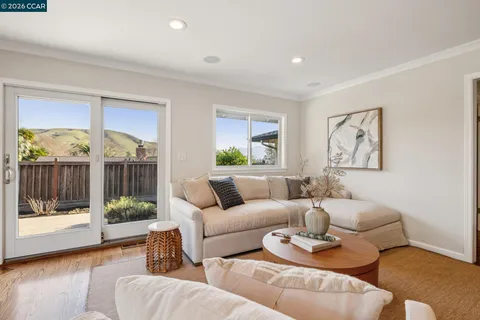 a living room with fireplace furniture and a large window