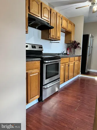 a kitchen with granite countertop wooden floors and stainless steel appliances
