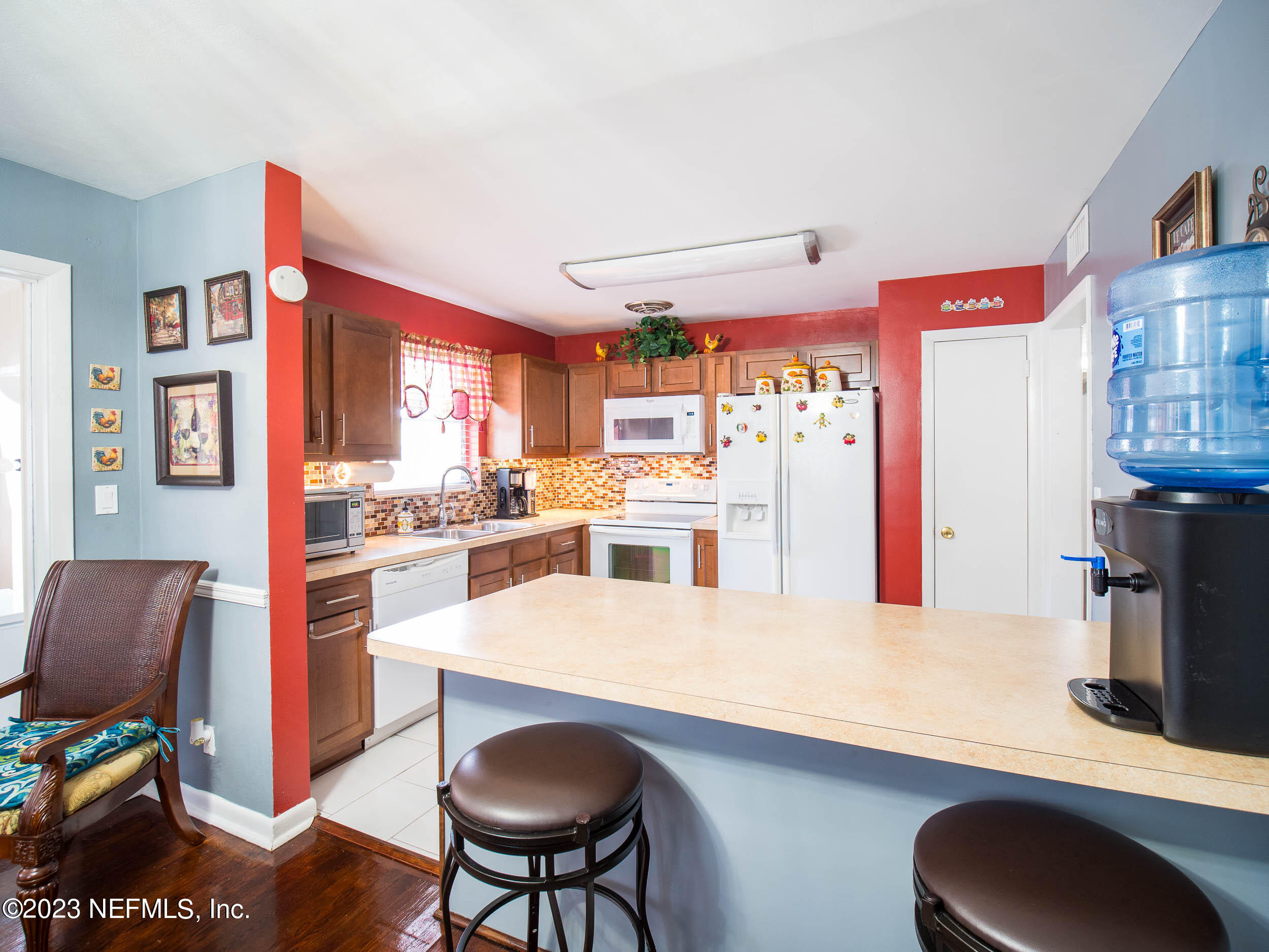 3145 Rogero Road Jacksonville, FL 32277 - Photo 7 of 21 a kitchen with stainless steel appliances kitchen island granite countertop a table chairs and a refrigerator