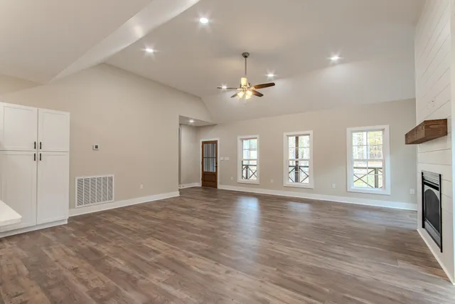 a view of an empty room with a window and fireplace