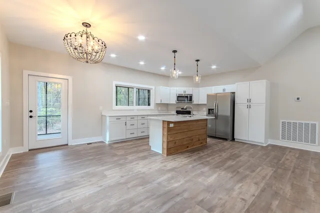 a large kitchen with a large window and stainless steel appliances