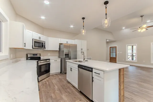 a kitchen with a sink a stove a refrigerator and a microwave