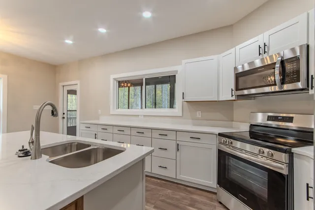 a kitchen with sink a microwave and cabinets