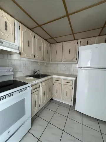 a kitchen with cabinets appliances and a sink