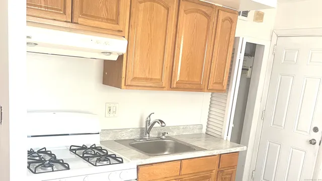 a kitchen with stainless steel appliances granite countertop a sink and a refrigerator