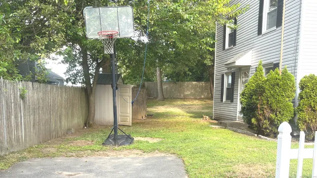 a backyard of a house with swimming pool and large trees