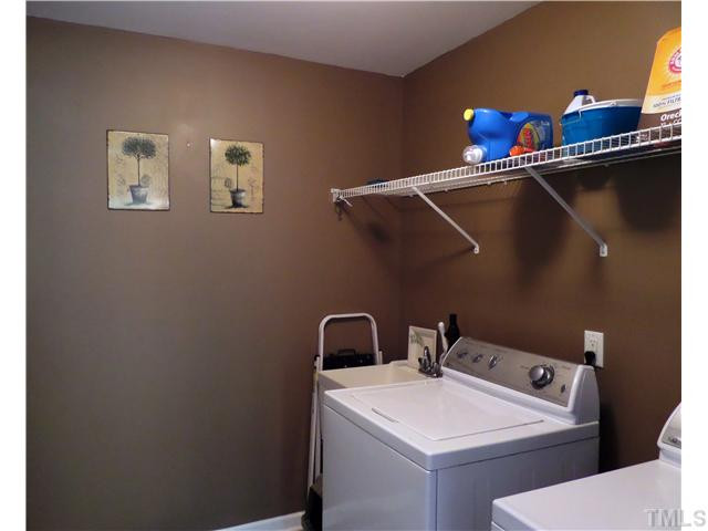 4441 Fairview Ridge Lane Apex, NC 27539 - Photo 10 of 25 utility room is downstairs-has a utility sink and is just beside garage entry if there happens to be a messy shoes to clean. Plenty of shelving for storage Laundry Room