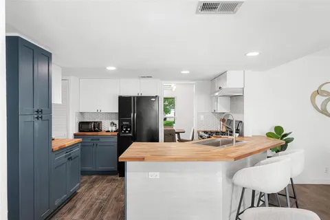 a kitchen with kitchen island granite countertop a sink cabinets and stainless steel appliances