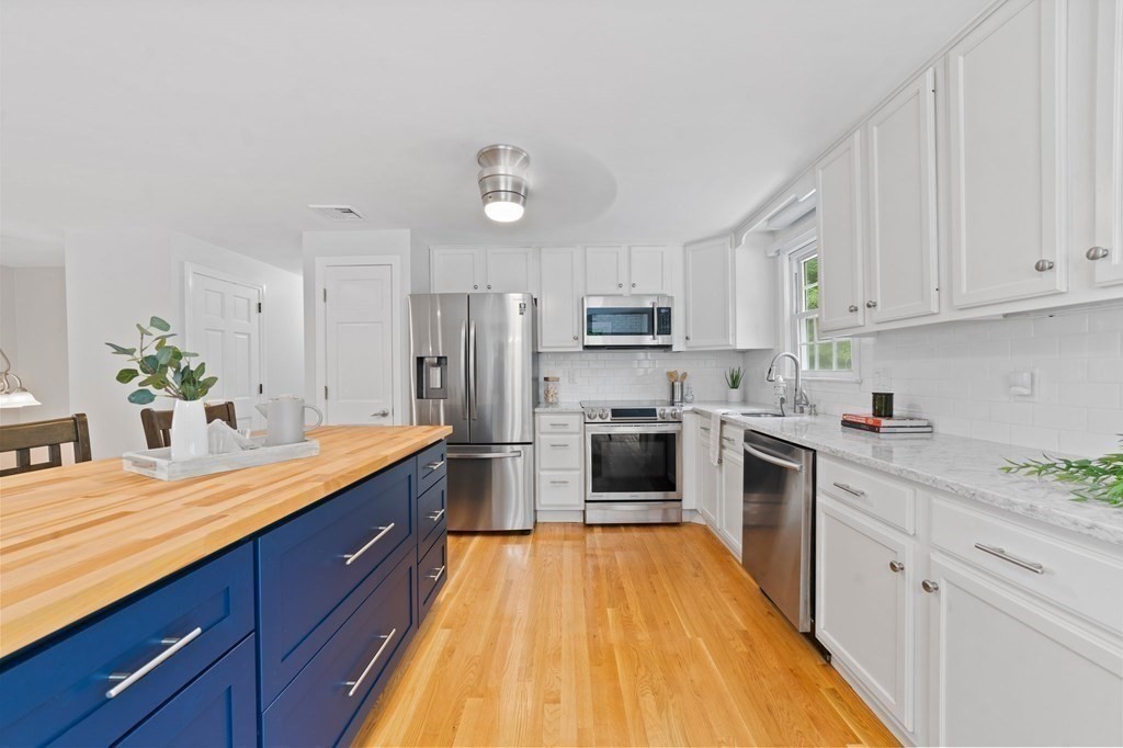56 Cedarcrest Road Hanover, MA 02339 - Photo 6 of 26 a kitchen with kitchen island granite countertop white cabinets stainless steel appliances and sink