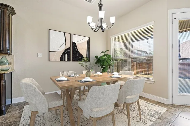 a dining room with wooden floor a chandelier a wooden table and chairs
