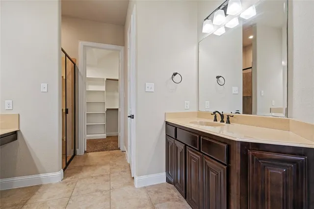 a bathroom with a granite countertop sink a toilet a mirror and shower