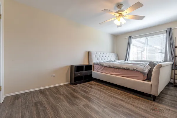 a spacious bedroom with a bed and a chandelier