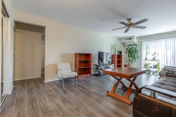 a living room with furniture a table and wooden floor