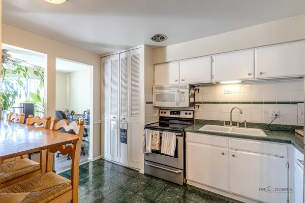 a kitchen with stainless steel appliances a stove a sink and white cabinets