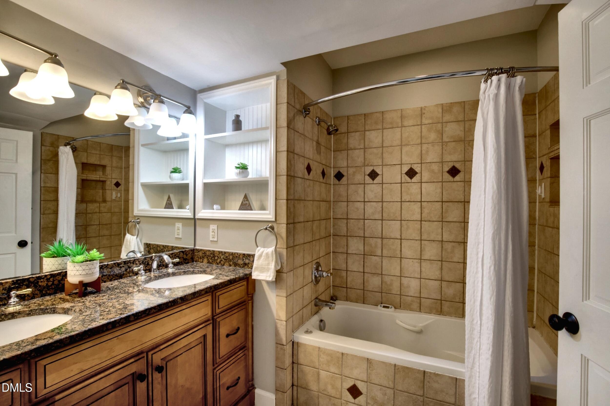 2329 Win Road Garner, NC 27529 - Photo 59 of 90 Double vanity with integrated sinks, granite-finish countertop, and wood-finish cabinetry