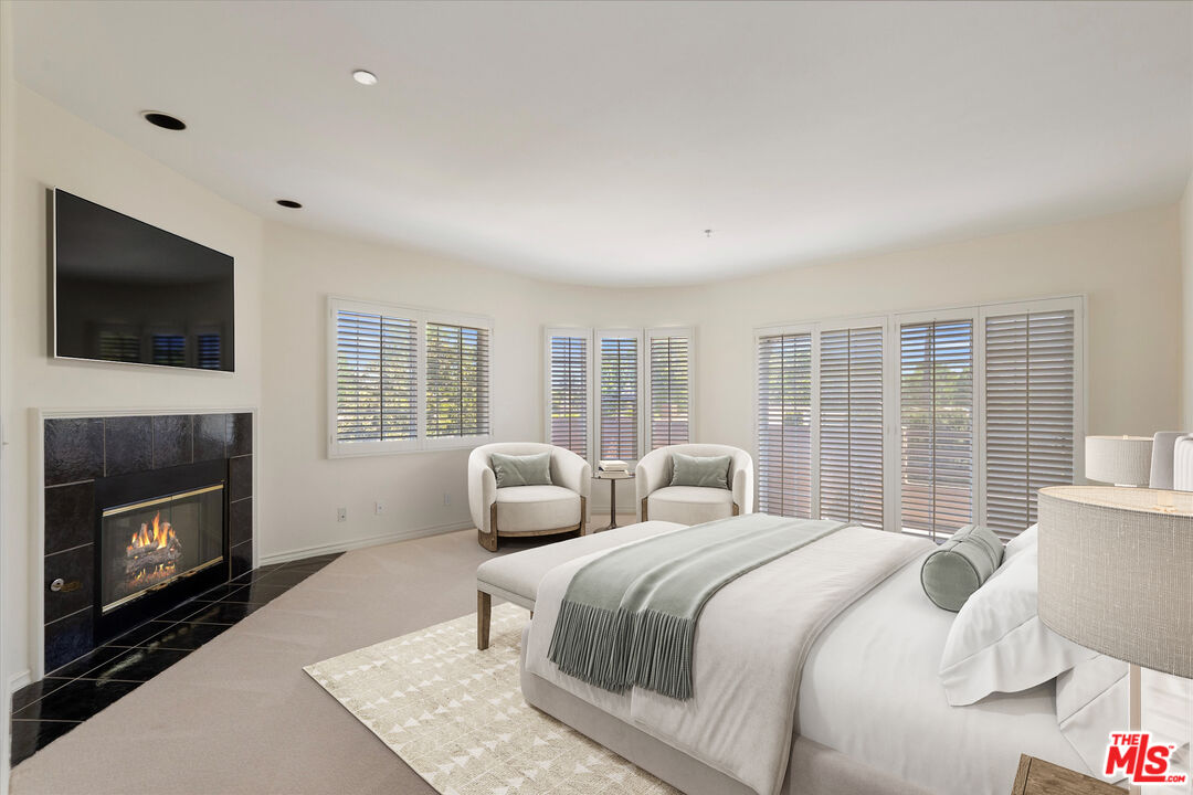 4310 Cahuenga Boulevard, Unit 304 Toluca Lake, CA 91602 - Photo 15 of 35 a bedroom with a balcony a bed and a television