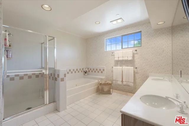 a spacious bathroom with a tub sink and shower