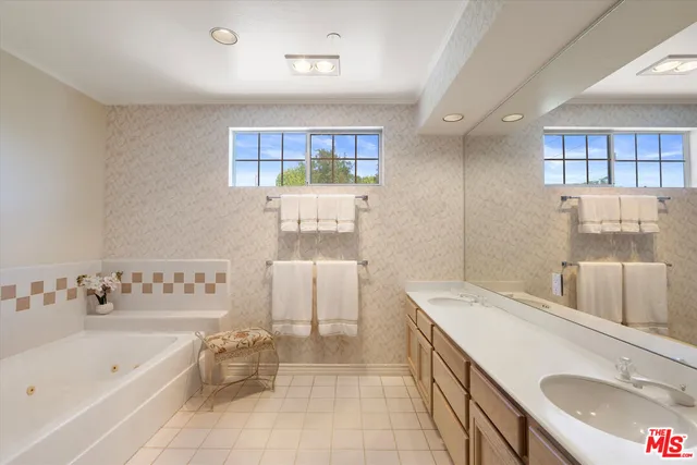a en suite bathroom with a granite countertop sink and a bathtub