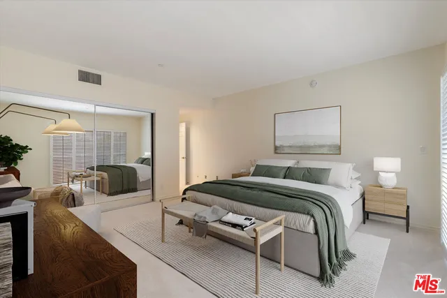 a bedroom with a bed a couch and a view of kitchen