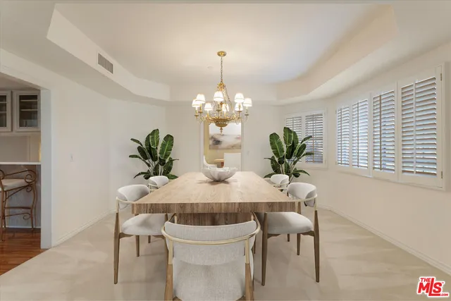 a dining room with furniture potted plants and wooden floor