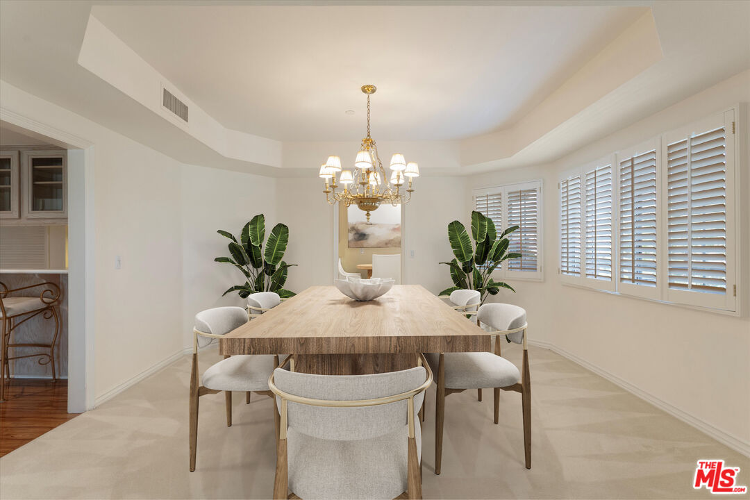 4310 Cahuenga Boulevard, Unit 304 Toluca Lake, CA 91602 - Photo 8 of 35 a dining room with furniture potted plants and wooden floor