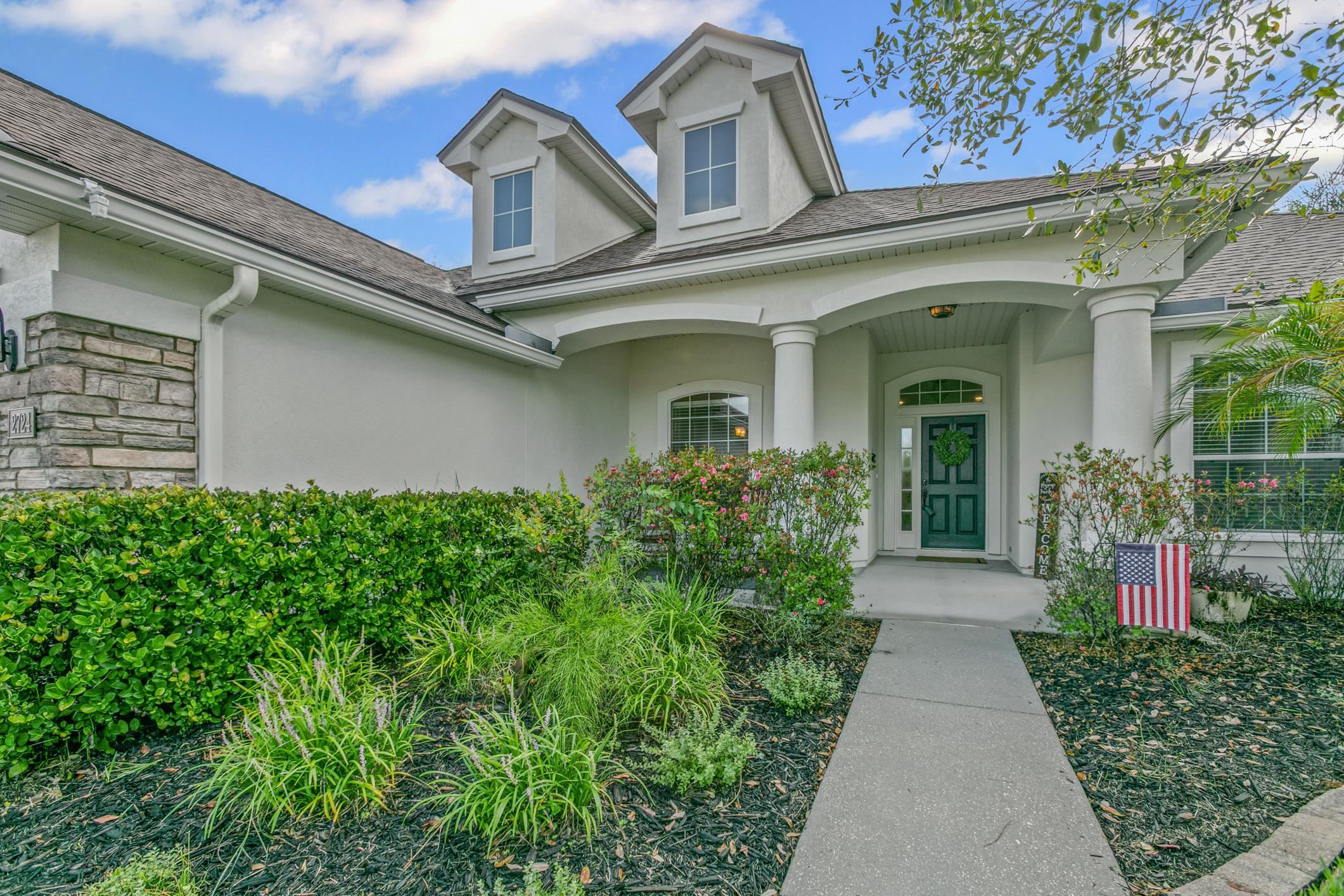 2724 North Portofino Road St. Augustine, FL 32092 - Photo 10 of 86 View of exterior entry with covered porch, roof with shingles, stucco siding, and stone siding